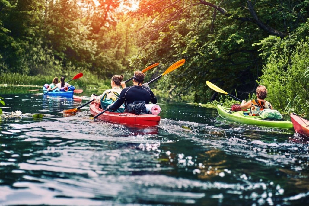 group of young people on kayak outing rafting down the river